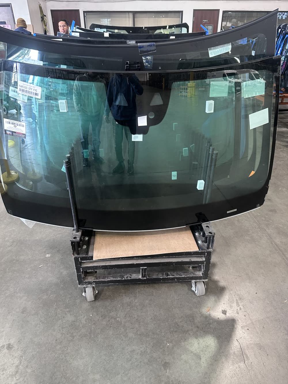 A windshield off the vehicle on a stand